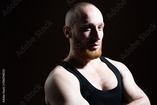 Man close up portrait, with llong shadow on black background low key. photo