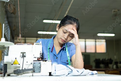 Tableau sur toile Tailors hold onto their heads due to stress while sewing clothes in the garment