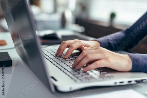 Women's hands on a laptop keyboard close-up