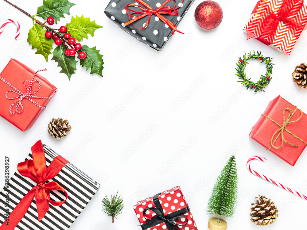 Gift boxes wrapped in striped and dotted black and white and red paper over white background. Christmas presents and ornament preparation. Copy space.
