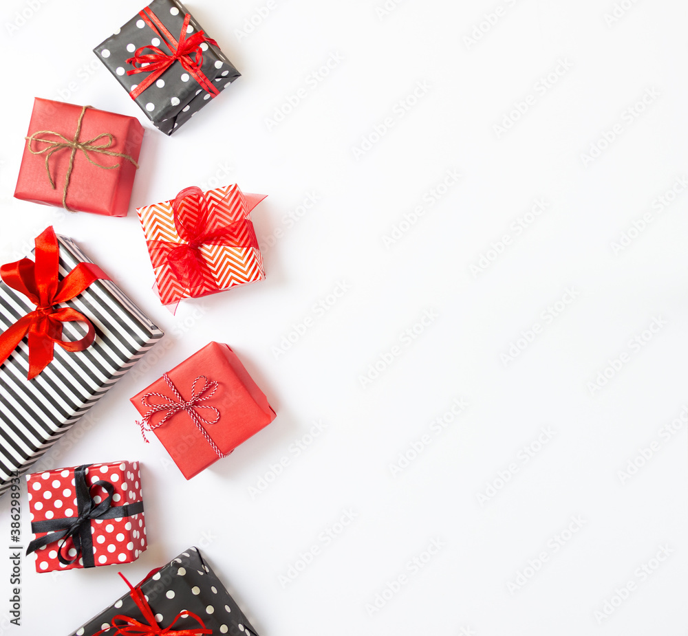 Top view of gift boxes wrapped in black and white striped, dotted and red paper over a white background. Various designs wrapped presents. Copy space