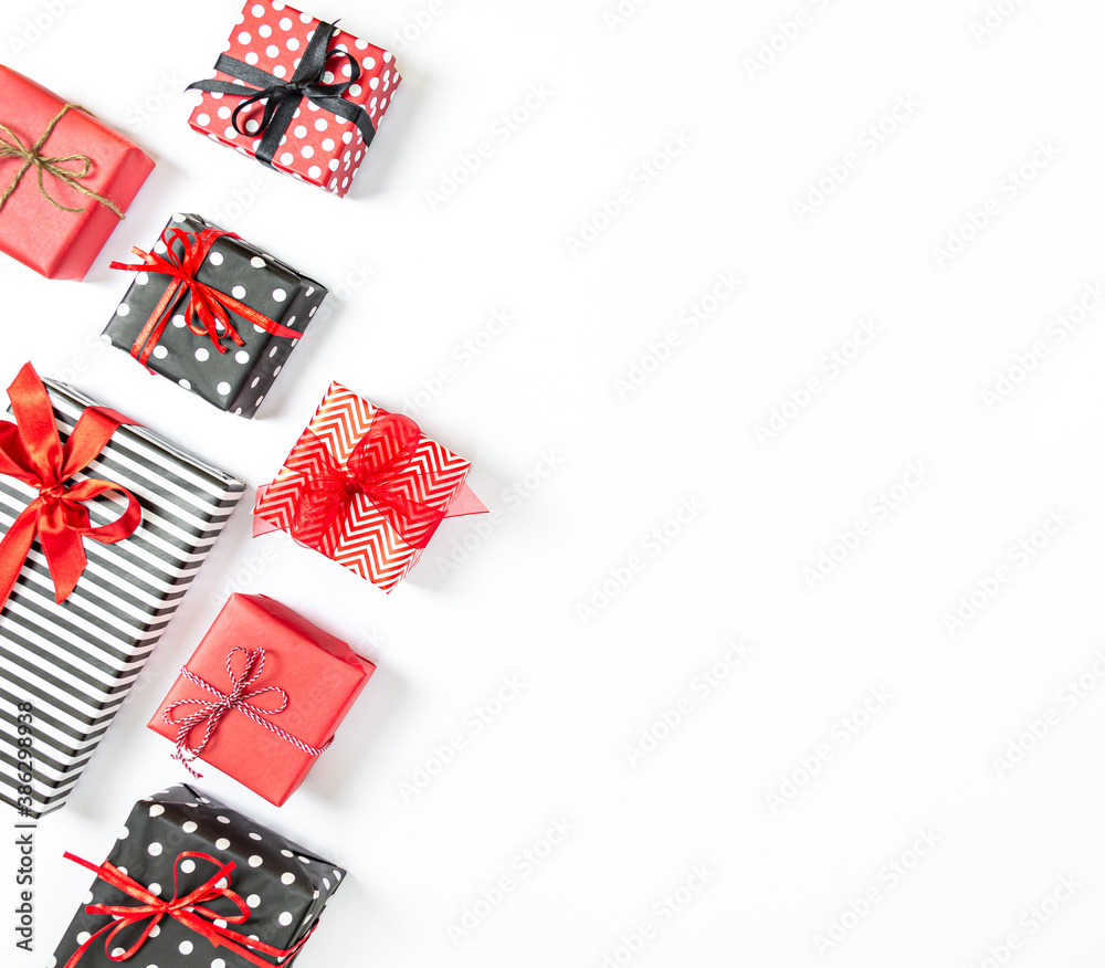 Top view of gift boxes wrapped in black and white striped, dotted and red paper over a white background. Various designs wrapped presents. Copy space