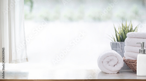 Fotografia Clean white bath towels  on wooden counter table, copy space.