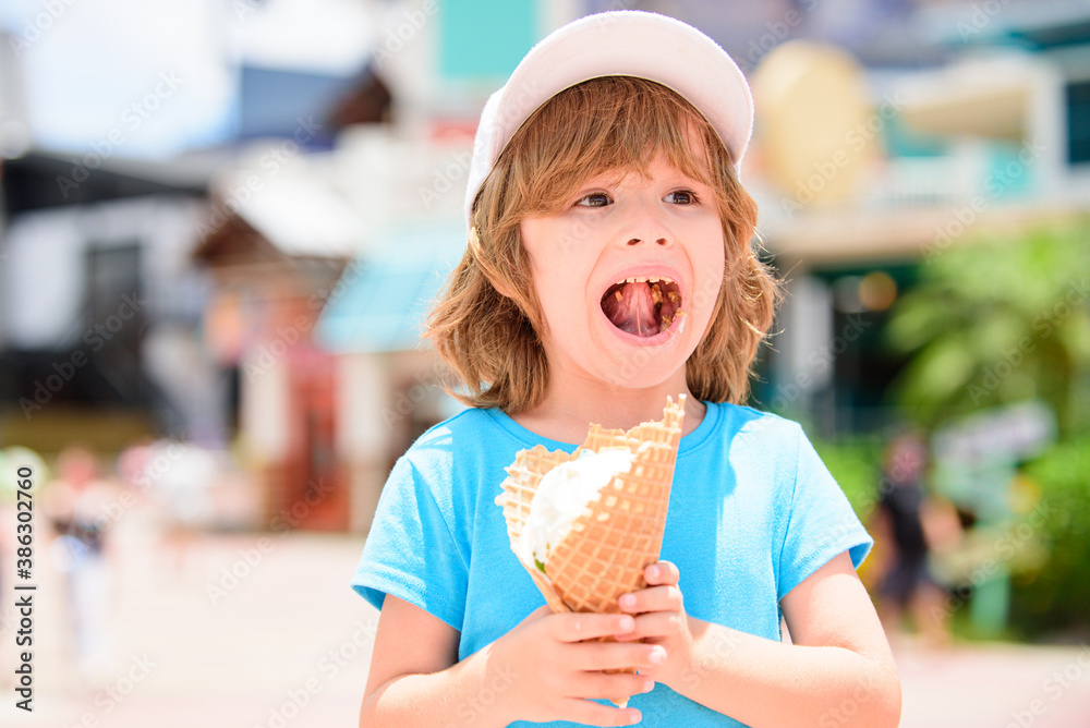 Sweet toddler boy eating ice cream over background with blurred bokeh. Sweet toddler boy eating ice cream over background with blurred bokeh.