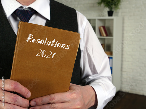 Business concept meaning Resolutions 2021 with sign on the sheet.
