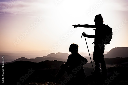 happy couple man and woman tourist at top of mountain at sunrise a hike in summer