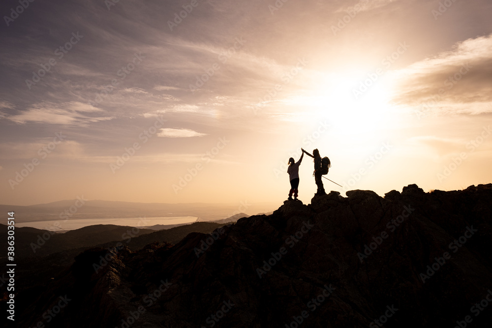 happy couple man and woman tourist at top of mountain at sunrise a hike in summer