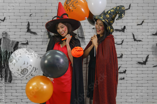halloween portrait of two women in witches costume with balloon
