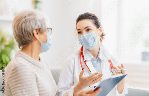 Doctor and senior woman wearing facemasks