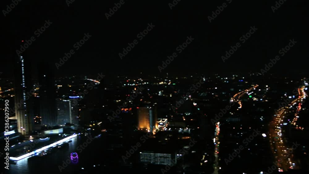 Panoramic view of a city skyline in the night with skyscrapers and busy highway glowing in the dark