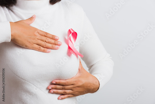 Wallpaper Mural Breast cancer awareness healthcare and medicine concept. Close up Asian woman wear t-shirt she have pink breast cancer awareness ribbon on chest she hold breast by hand, isolated on white background Torontodigital.ca
