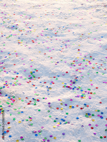 Colorful confetti glitter on the snow after holiday.
