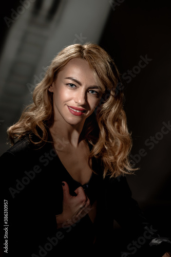 Beautiful fashionable sexy woman with wavy hairstyle posing on vintage background