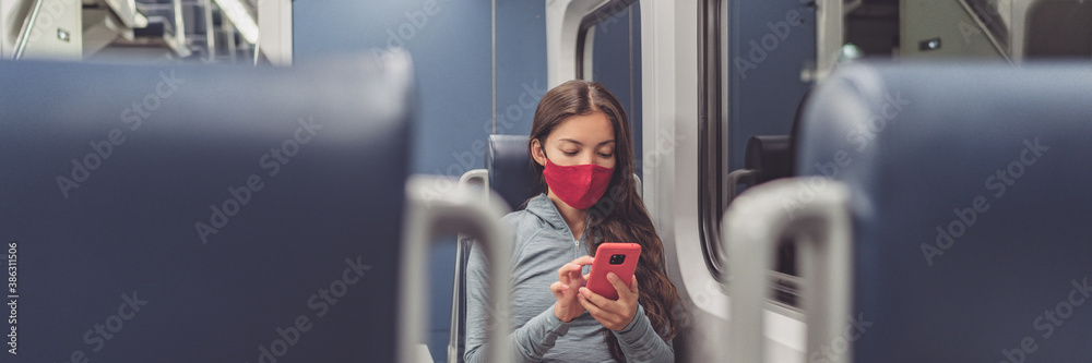 Train passenger using mobile phone during travel commute wearing face mask for coronavirus pandemic. Panoramic banner of people lifestyle commuting after work at night. - obrazy, fototapety, plakaty 