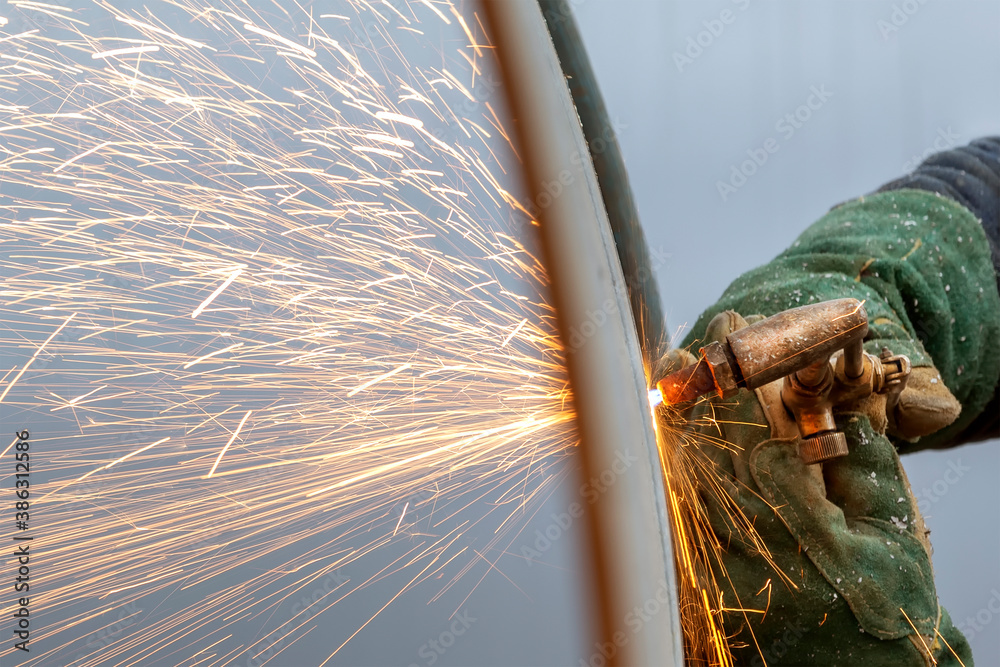 The worker is cutting to metal plate with manual flame cutting process