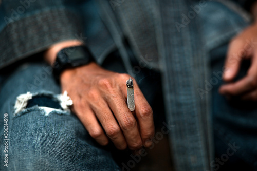 Close up of hand holding a cigarette.