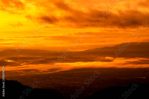 Beautiful landscape at sunset sky with clouds on peak of mountains.