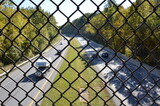 metal fence over highway or road with cars