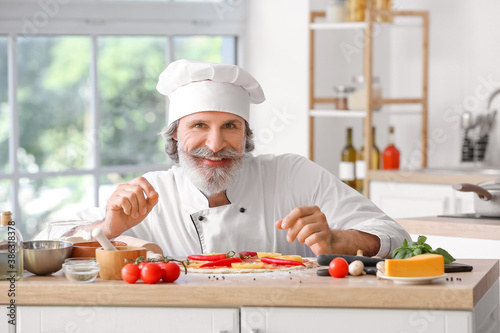 Mature male chef cooking ta...