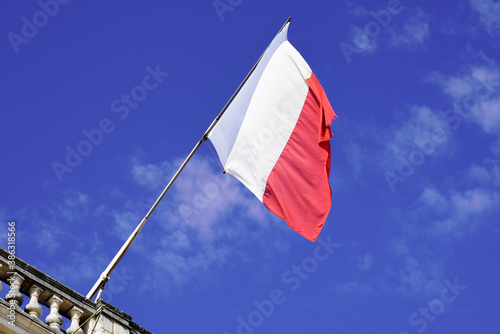 French flag waving in front of facade of city hall waving in blue sky of france