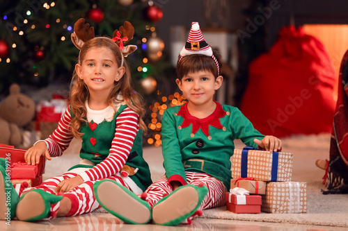 Cute little elves with gifts at home on Christmas eve