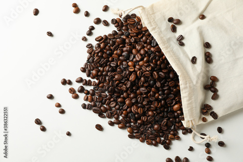 Bag with coffee seeds on white background