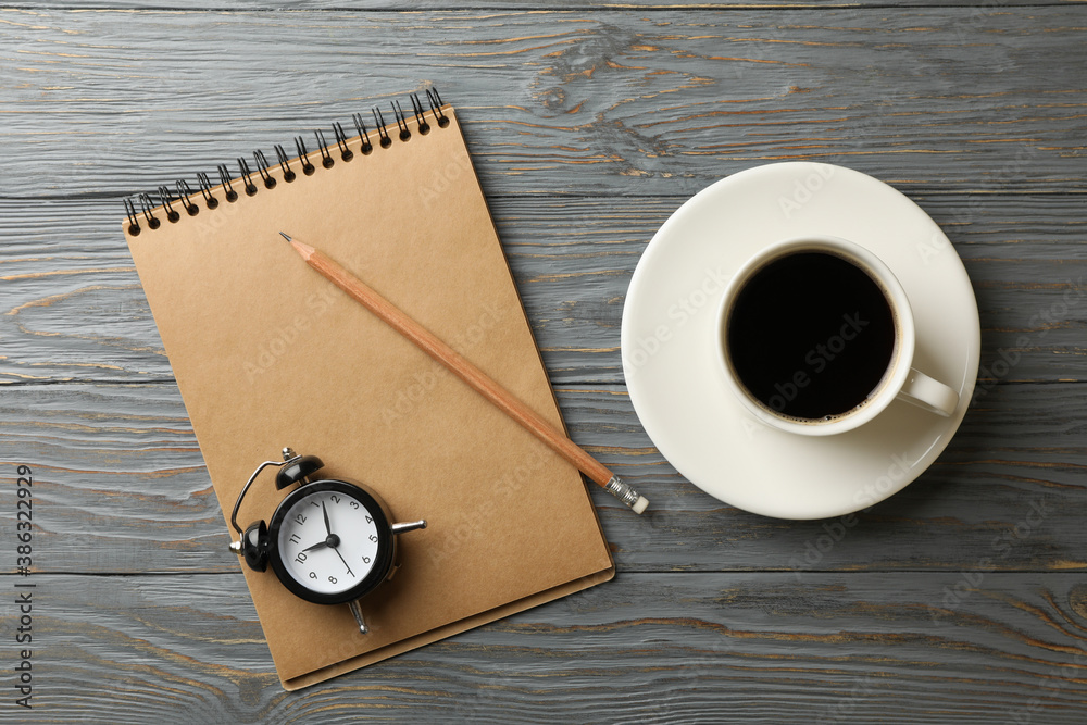 Clock, notebook, pencil and cup of coffee on wooden background Clock, notebook, pencil and cup of coffee on wooden background