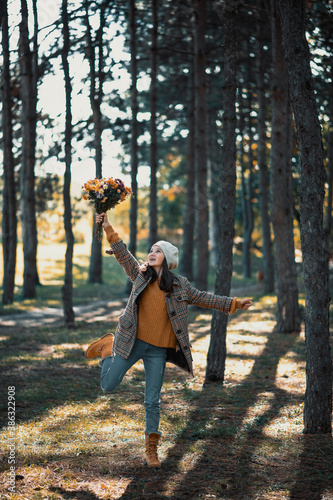 Fashionable teenage girl holding  autumns flowers