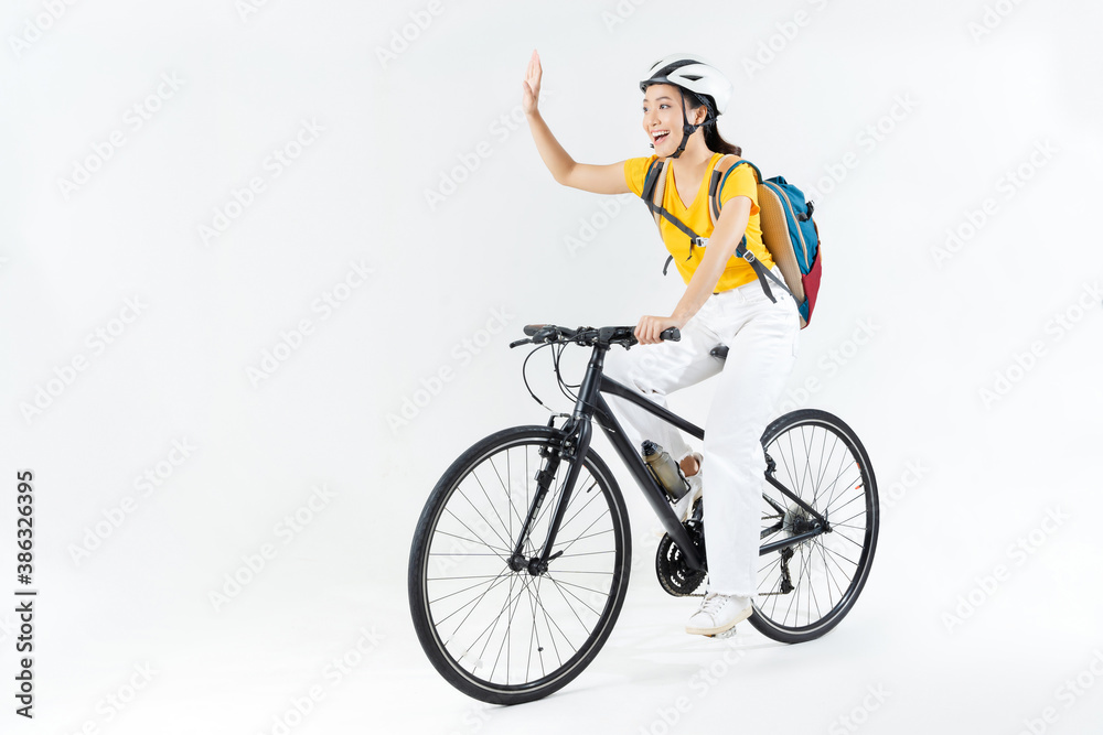 Asian beautiful woman, she is riding a city bike to work.She is greeting.