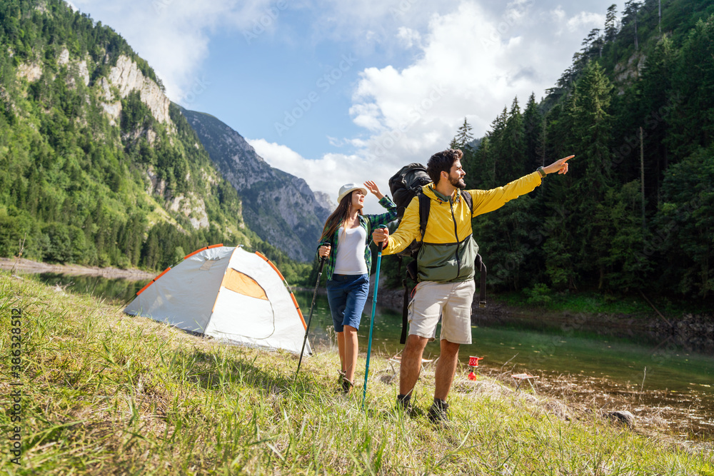 Happy couple smiling outdoors on hiking trip. Young couple enjoying nature.