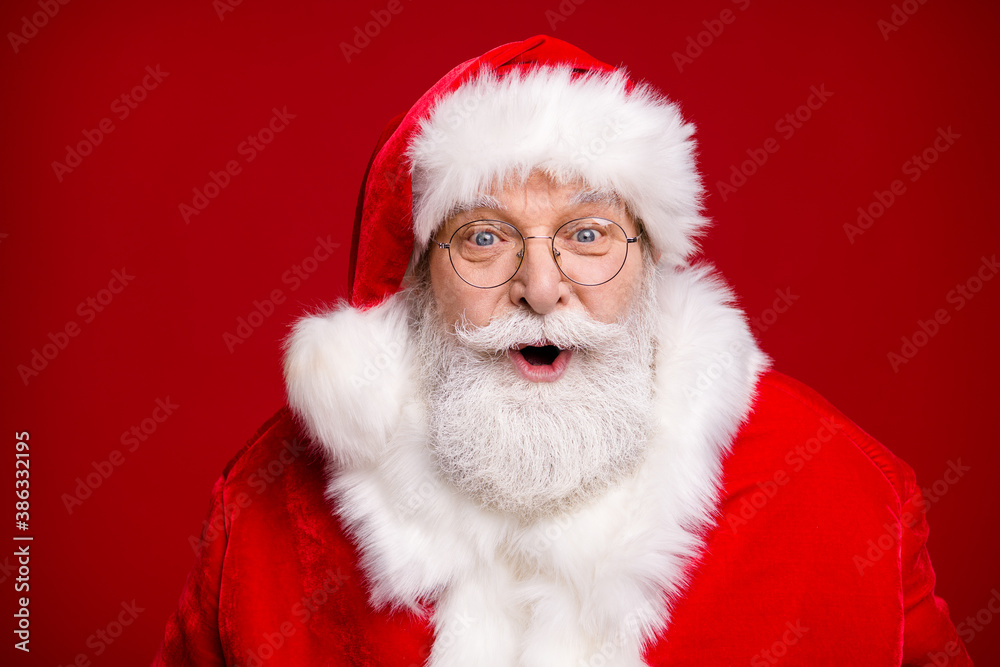 Photo of retired old man grey beard open mouth amazed look see children sing christmas carol want gift prepare present wear santa costume coat spectacles headwear isolated red color background Photo of retired old man grey beard open mouth amazed look see children sing christmas carol want gift prepare present wear santa costume coat spectacles headwear isolated red color background