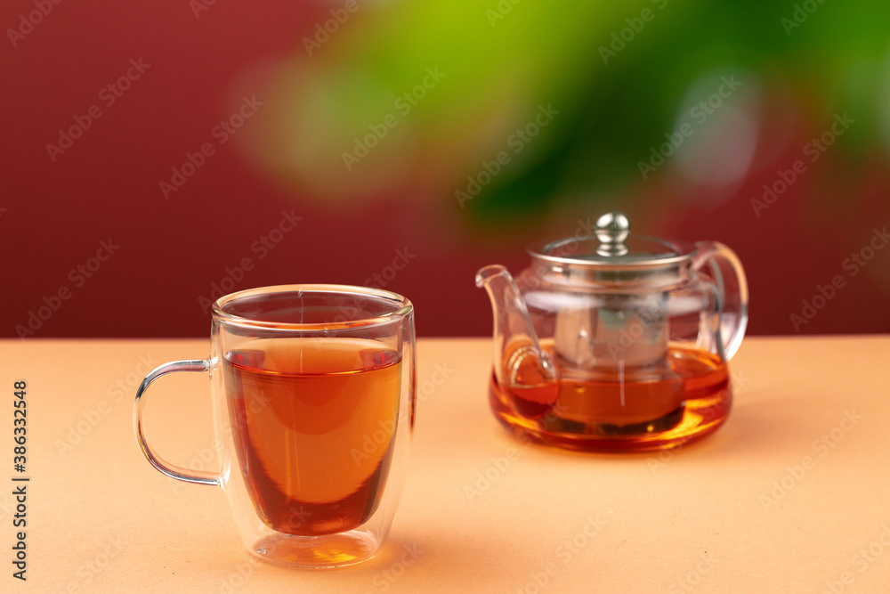 Glass teapot and cup with black tea Glass teapot and cup with black tea