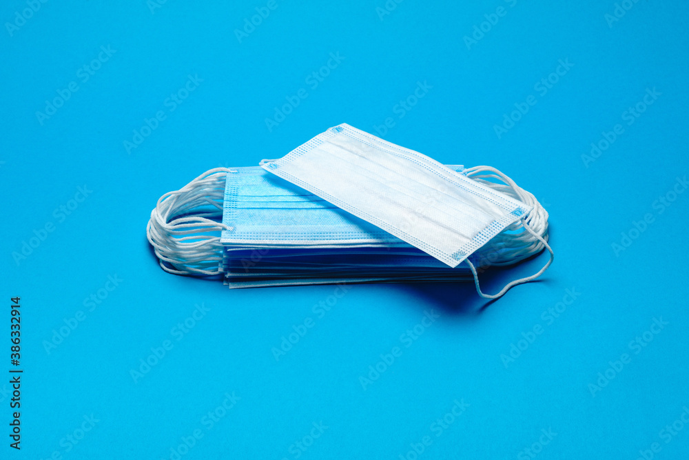Stack of Disposable blue medical face masks on blue background Stack of Disposable blue medical face masks on blue background