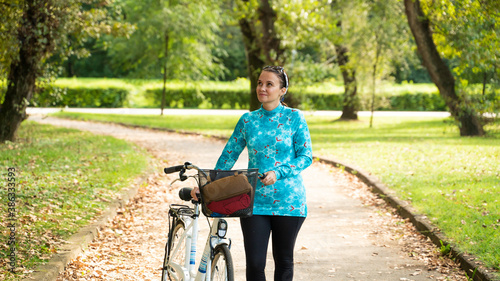 Portrait of woman with bicycle during sunrise at park, Zagreb, Croatia.