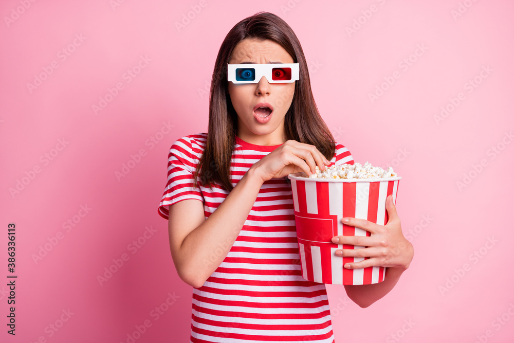 Photo portrait of shocked girl wearing 3d glasses keeping box with pop corn watching film isolated on pastel pink color background Photo portrait of shocked girl wearing 3d glasses keeping box with pop corn watching film isolated on pastel pink color background