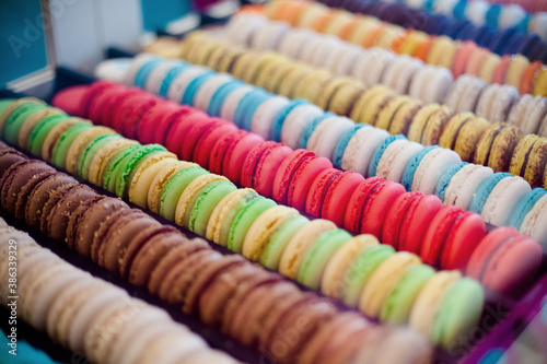Closeup of a rows and columns of multicolored macarons, traditional French cookies.