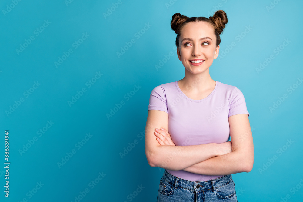 Photo of attractive confident teen lady two buns good mood toothy smile charming nice freelancer arms crossed look side empty space wear casual purple t-shirt isolated blue color background Photo of attractive confident teen lady two buns good mood toothy smile charming nice freelancer arms crossed look side empty space wear casual purple t-shirt isolated blue color background