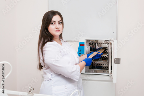  A handsome cosmetologist with long dark hair is performing an electrolysis procedure. In the beautician's office. Close-up.