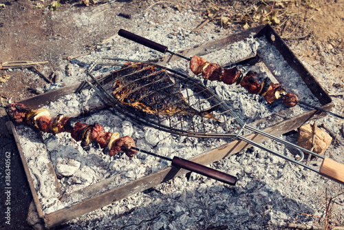 Outdoor cooking skewered meat and fish over charcoal. Selective focus