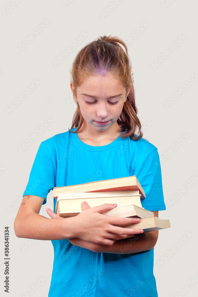 A little girl holds stack of school books A little girl holds stack of school books