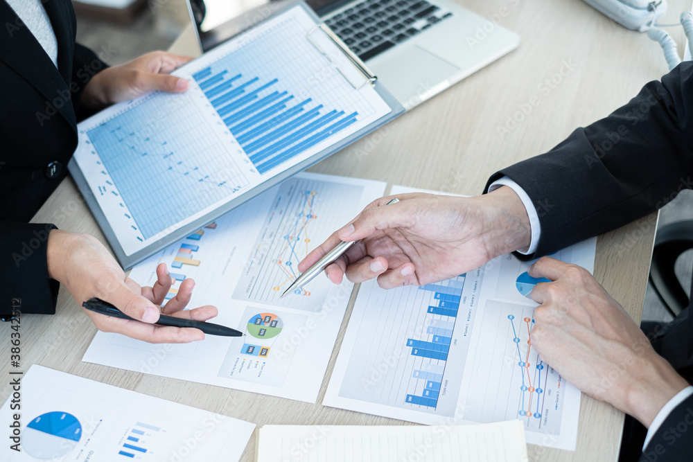 Two business leaders talk about charts, financial graphs showing results are analyzing and calculating planning strategies, business success building processes Two business leaders talk about charts, financial graphs showing results are analyzing and calculating planning strategies, business success building processes
