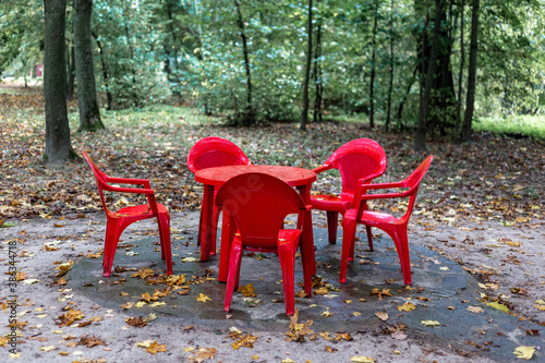 Red plastic chairs and table in the park