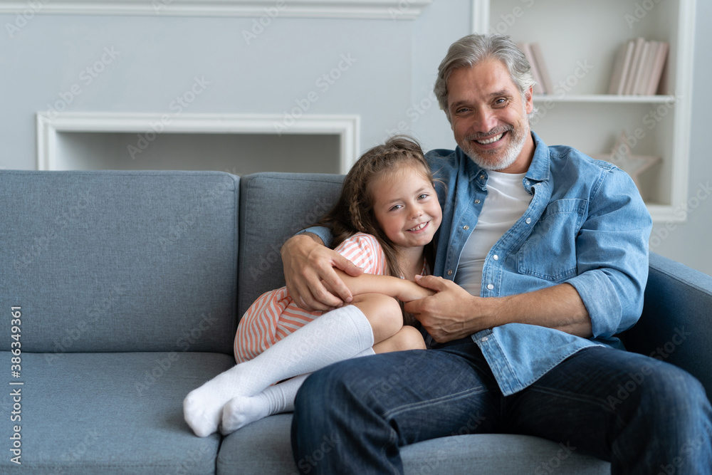 Happy sweet girl hugging her father at home Happy sweet girl hugging her father at home