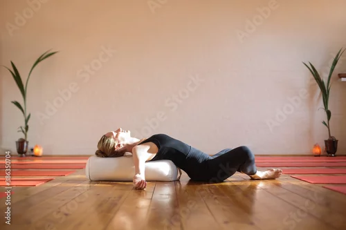 Fototapeta Woman practicing yoga at home during quarantine