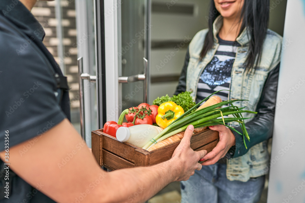 Εκτύπωση καμβά A courier with a backpack and food delivered an online order to the customer's home