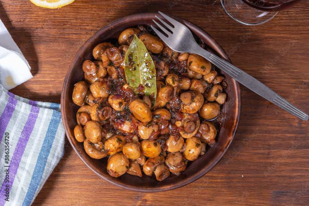 Vegan mushroom fricassee with garlic on a rustic background close-up, top view - mushrooms with garlic, French cuisine. Vegan mushroom fricassee with garlic on a rustic background close-up, top view - mushrooms with garlic, French cuisine.