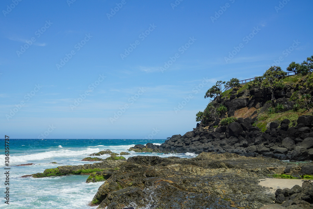 Coastal view with rocky headland at Flagstaff Beach, Coolangatta, Queensland.