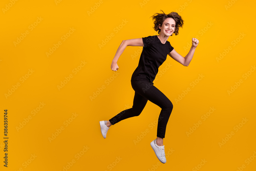 Full length body size profile side view of lovely cheerful girl jumping running fast speed isolated bright yellow color background