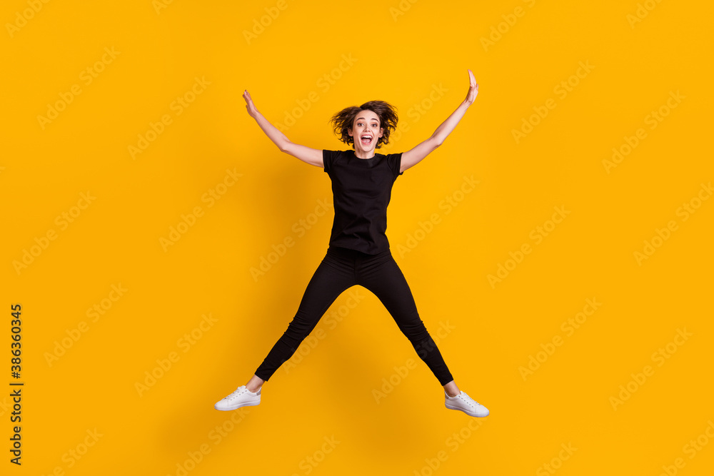 Full length body size view of skinny funky cheerful girl jumping having fun free time isolated bright yellow color background