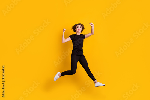 Full length body size view of slender lucky cheerful girl jumping having fun rejoicing isolated bright yellow color background